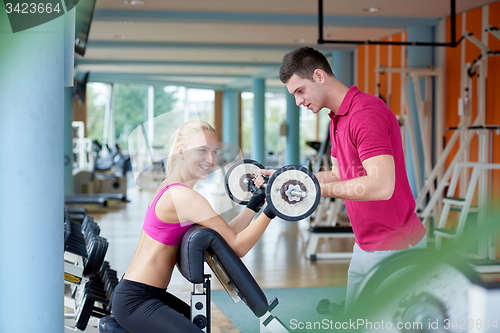 Image of young sporty woman with trainer exercise weights lifting
