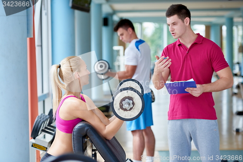 Image of young sporty woman with trainer exercise weights lifting