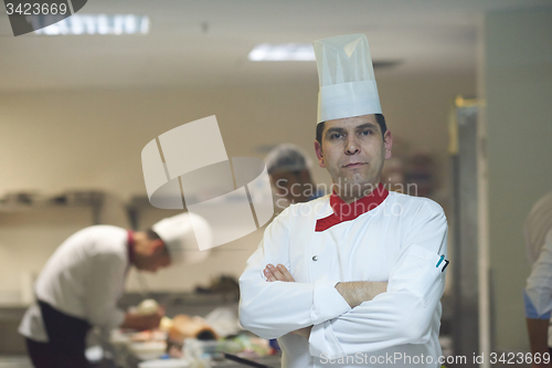 Image of chef in hotel kitchen preparing and decorating food