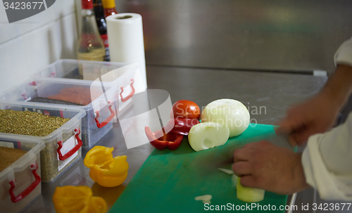 Image of chef in hotel kitchen  slice  vegetables with knife
