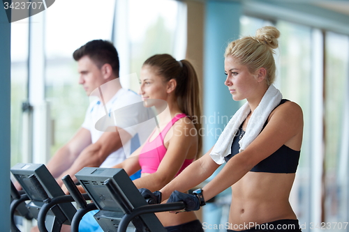 Image of friends  exercising on a treadmill at the bright modern gym