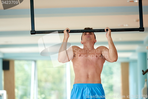 Image of handsome young mand working out in gym