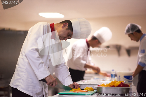 Image of chef in hotel kitchen preparing and decorating food