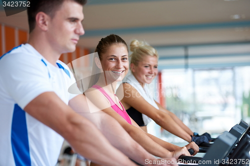 Image of friends  exercising on a treadmill at the bright modern gym