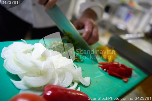 Image of chef in hotel kitchen  slice  vegetables with knife