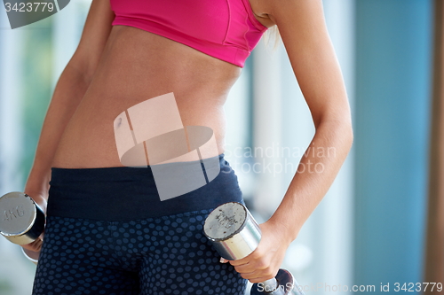 Image of lifting some weights and working on her biceps in a gym