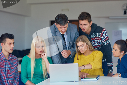 Image of group of students getting suppport from teacher