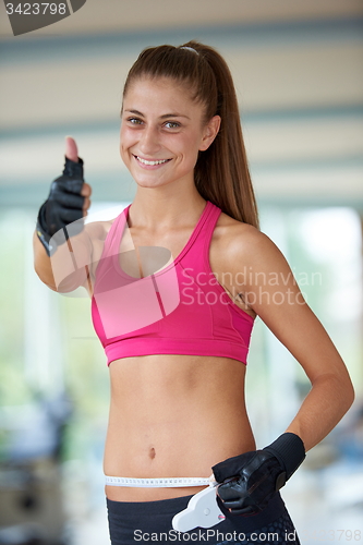 Image of young fit woman measuring belly