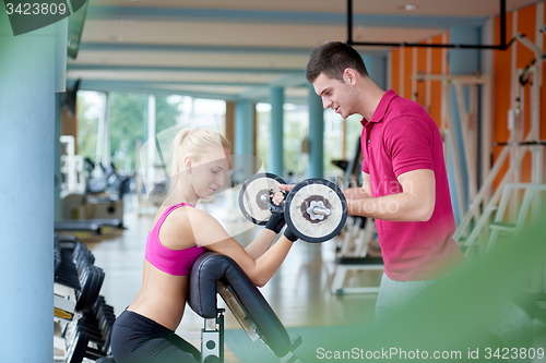 Image of young sporty woman with trainer exercise weights lifting