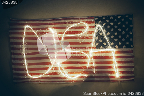 Image of weathered American flag with word USA written on it