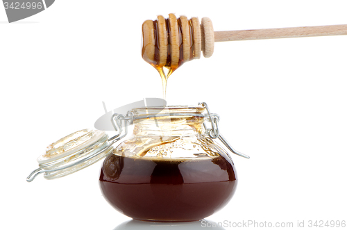 Image of Jar of honey with wooden drizzler