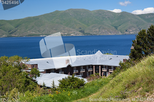 Image of Sevan lake shore with a house and a hill