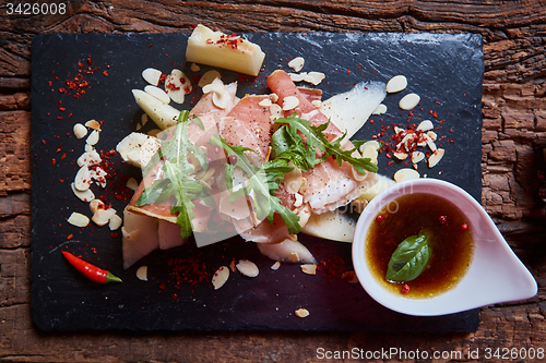 Image of salad of fresh melon with thin slices prosciutto