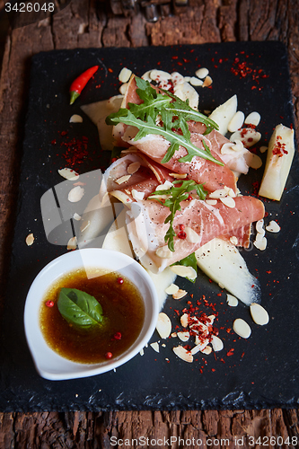 Image of salad of fresh melon with thin slices prosciutto