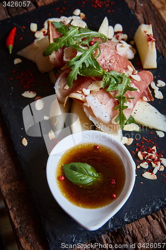 Image of salad of fresh melon with thin slices prosciutto