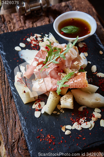 Image of salad of fresh melon with thin slices prosciutto