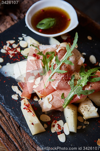 Image of salad of fresh melon with thin slices prosciutto