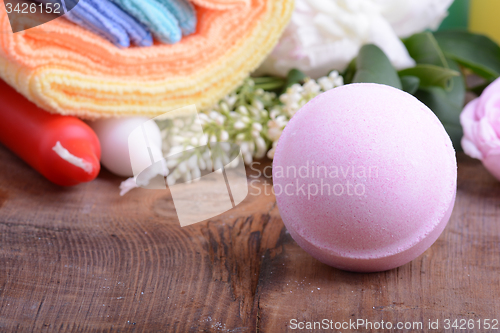 Image of sea salt, towels, aroma oil, flower and on wooden plate 