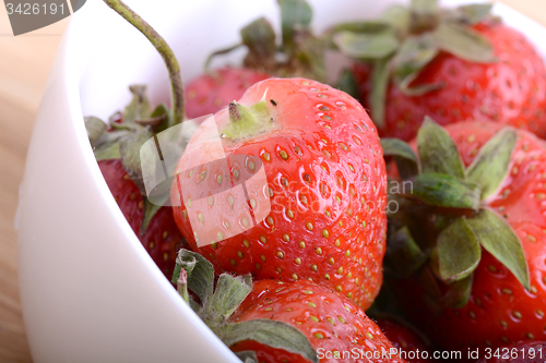 Image of Closeup of large fresh strawberries in white bowl
