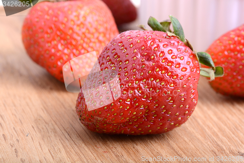 Image of Strawberry set on wooden plate close up