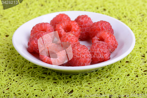 Image of Fresh raspberries. Closeup of fruits on a white plate
