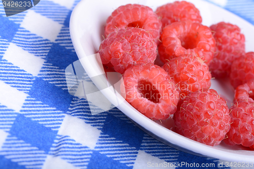 Image of fresh raspberries on the white plate