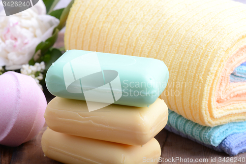Image of towels set, aroma therapy, soap and sea salt on wooden plate 