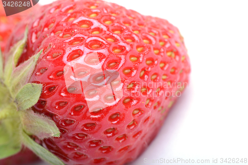 Image of Close-up detail of a fresh red strawberry with leaves