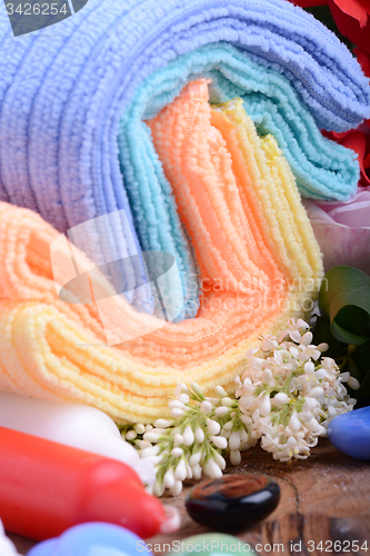 Image of Spa still life with aromatic candles, stones, flower and towel, close up