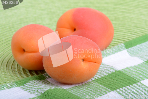 Image of Full peaches close up on green material background.