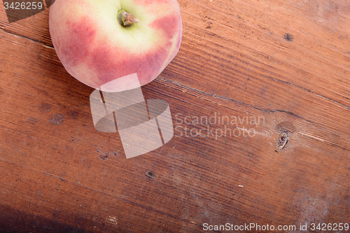 Image of Peach on wooden plate