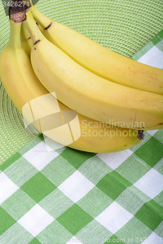 Image of Bunch of ripe bananason green material background