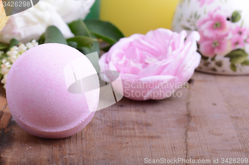 Image of sea salt, towels, aroma oil, flower and on wooden plate 