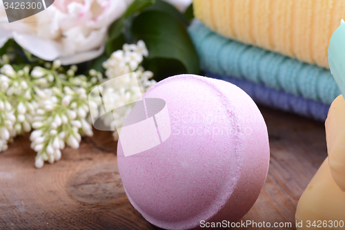 Image of towels, aroma spa, flower and sea salt on wooden plate 