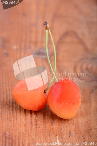 Image of wooden plate with dark red juicy cherries close up