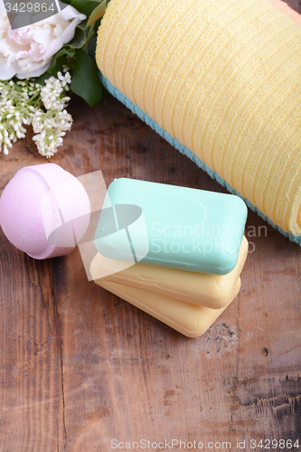 Image of towels set, aroma therapy, soap and sea salt on wooden plate 