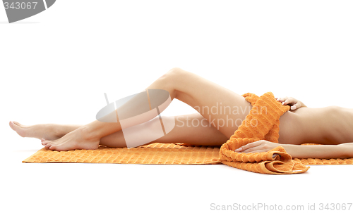 Image of long legs of relaxed lady with orange towel #4