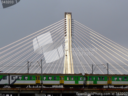 Image of Train passing in front of a suspension bridge