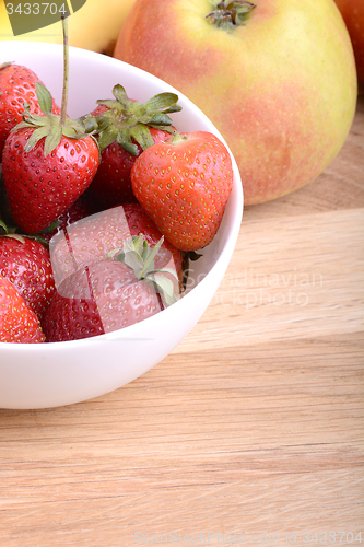Image of Close-up shot of variety of fruits on old wooden plate