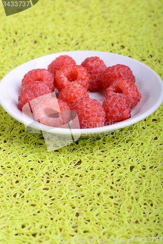 Image of fresh raspberries on the white plate