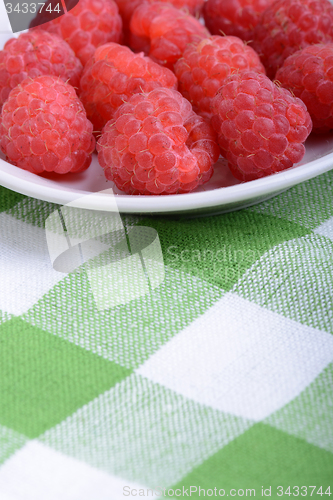 Image of fresh raspberries on the white plate