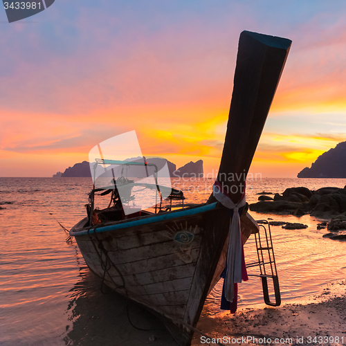 Image of Traditional wooden longtail boat on beach in sunset, Thailand.
