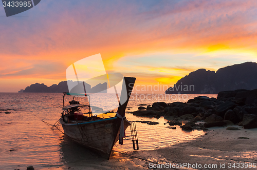 Image of Traditional wooden longtail boat on beach in sunset, Thailand.