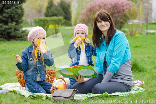 Image of Two girls eating a banana on a picnic