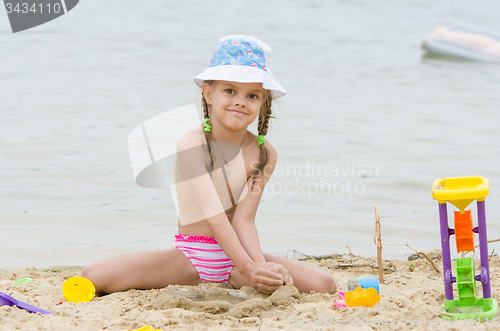 Image of Five-year girl on a river in the sand beach Flashes