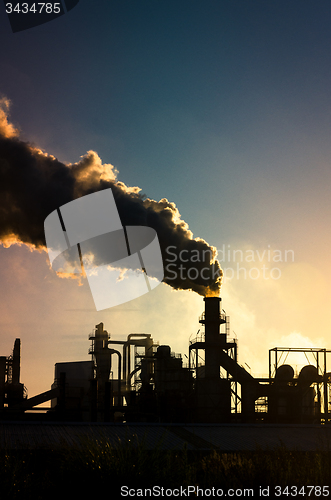 Image of Smoking chimney  at sunset 