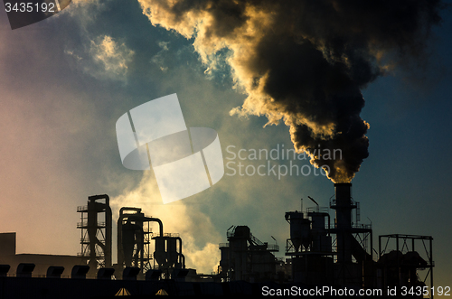 Image of Smoking chimney  at sunset 