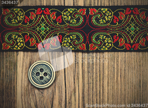 Image of old band with embroidered ornaments and vintage button