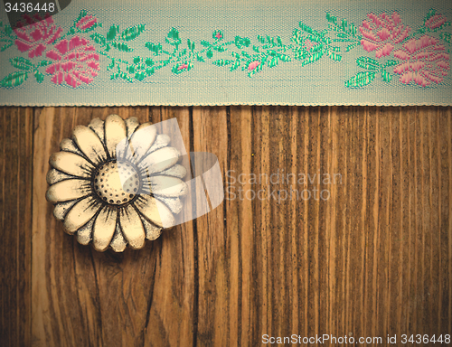 Image of vintage aqua color tape with embroidered ornaments and old butto