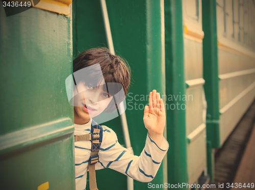 Image of boy waves his hand from railcar